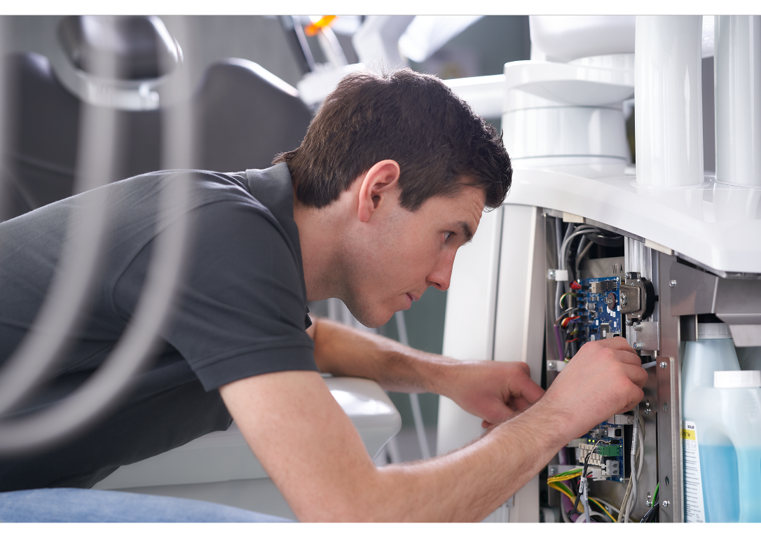 A man repairing a broken down dental unit